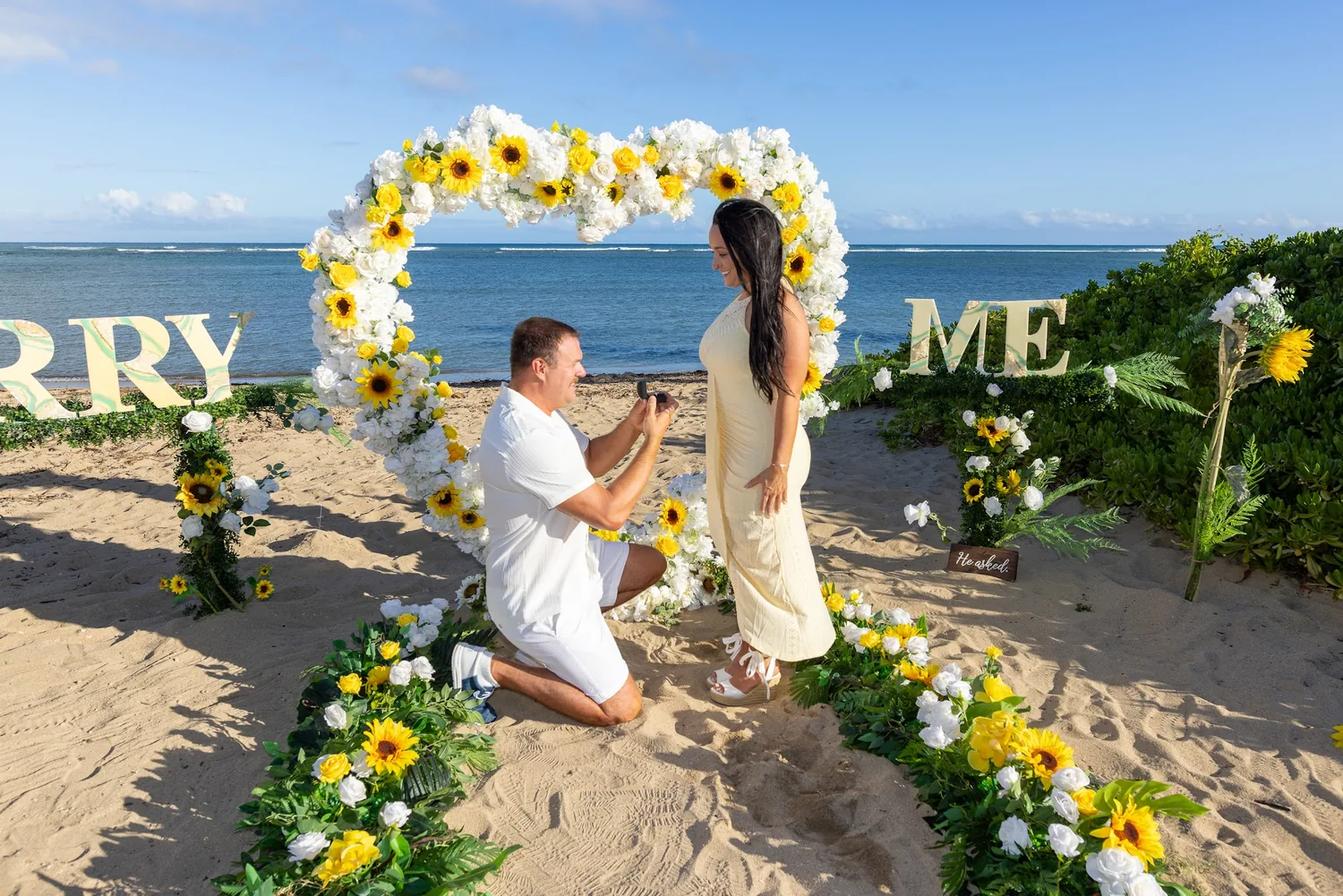 Furman kneeling beside the MARRY ME letters