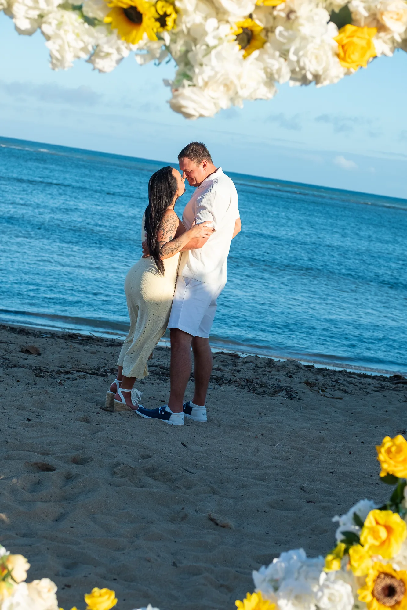 Sunflowers around the couple by the water