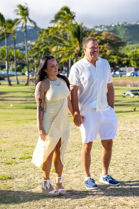 Makenzi in a soft yellow dress beside Furman under the palms