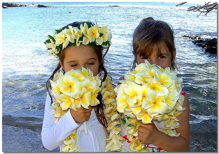 Flower girl smelling a yellow plumeria bouquet
