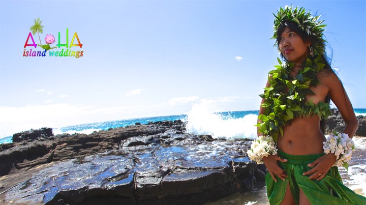 Hula dancer in a haku lei dancing by the waves on Oahu
