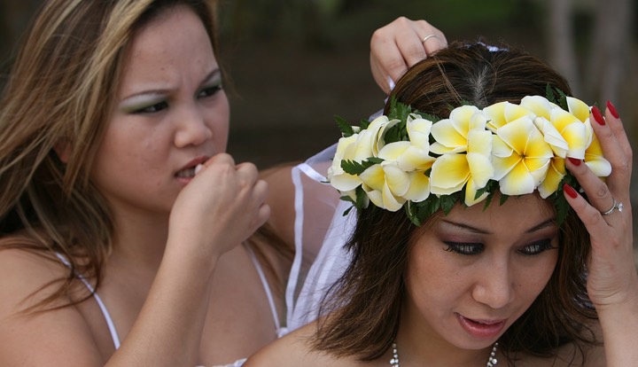 Bridesmaids helping Christy pin on her plumeria head lei