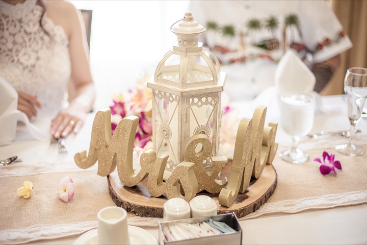 Gold Mr & Mrs letters and a white lantern on the sweetheart table at the reception