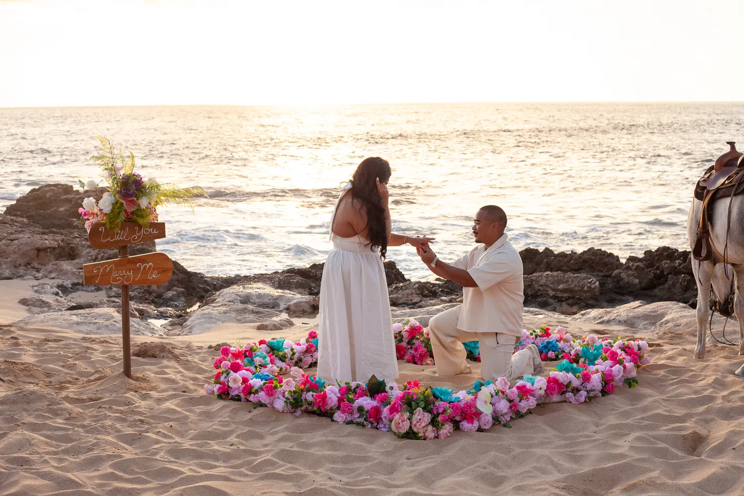 Down on one knee at the flower heart, at a horseback proposal on Oahu
