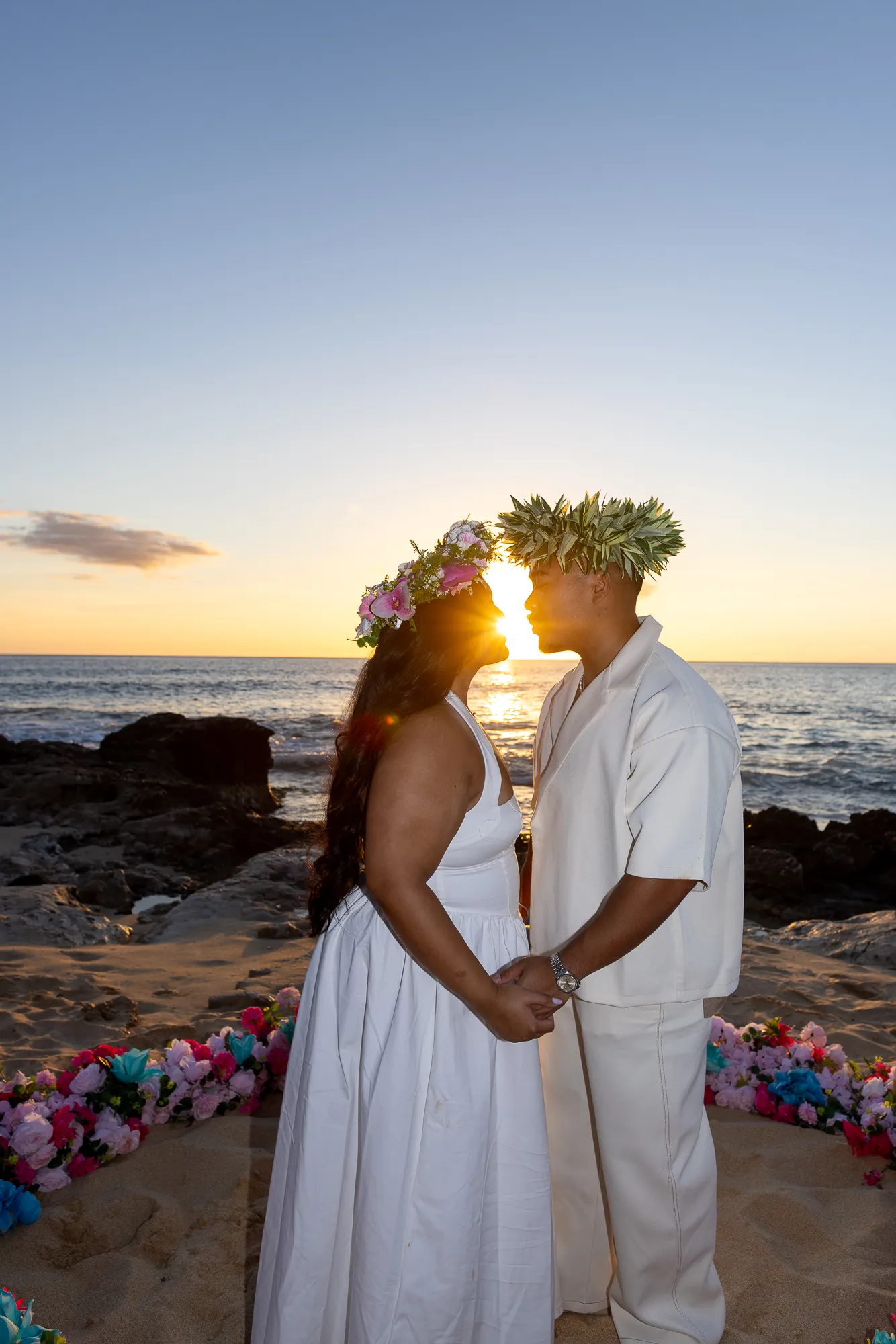 Holding hands in haku leis at sunset, at a horseback proposal on Oahu