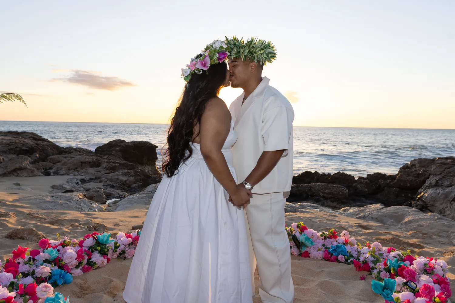 Kiss in haku leis by the ocean, at a horseback proposal on Oahu