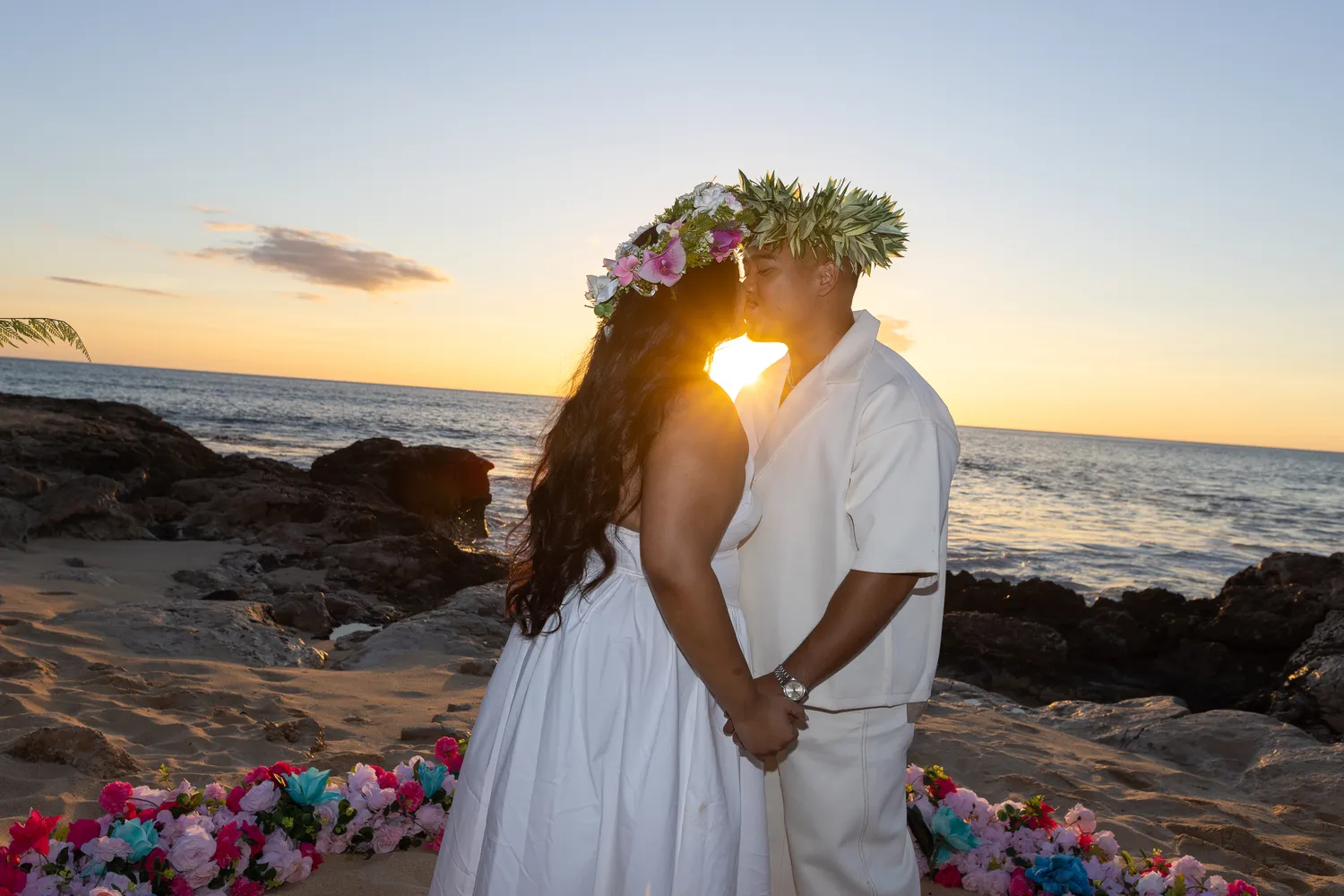 Sunset kiss in haku leis, at a horseback proposal on Oahu