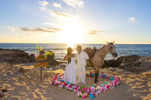 Buckskin horse beside the proposal heart at sunset, at a horseback proposal on Oahu