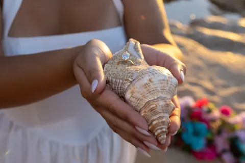 Conch shell held in her hands, at a horseback proposal on Oahu
