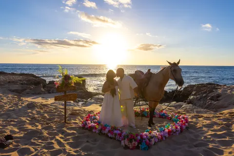 Couple and buckskin horse in the flower heart, at a horseback proposal on Oahu