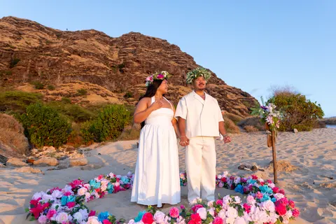 Couple cheering under the mountain cliffs, at a horseback proposal on Oahu