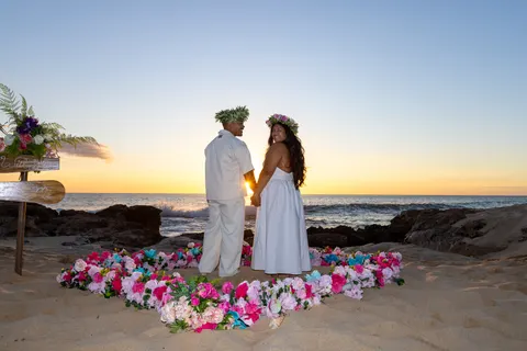 Couple in the flower heart with wooden sign, at a horseback proposal on Oahu