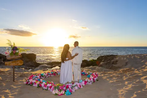 Couple standing in the flower heart at sunset, at a horseback proposal on Oahu