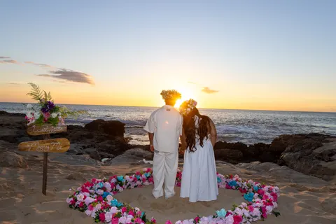 Couple watching the sunset in the flower heart, at a horseback proposal on Oahu