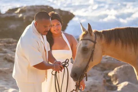 Holding the reins of the buckskin horse, at a horseback proposal on Oahu