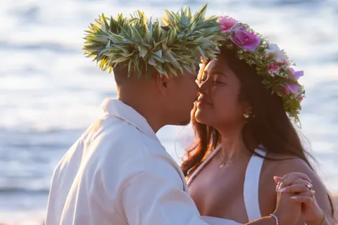 Kiss in haku leis by the waves, at a horseback proposal on Oahu