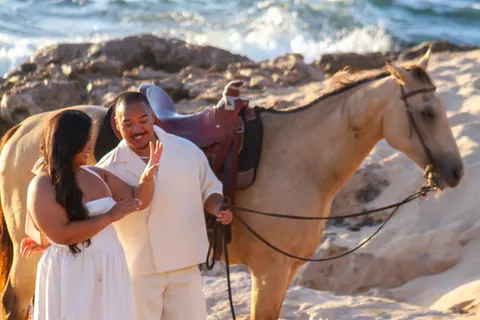 Laughing together beside the buckskin horse, at a horseback proposal on Oahu