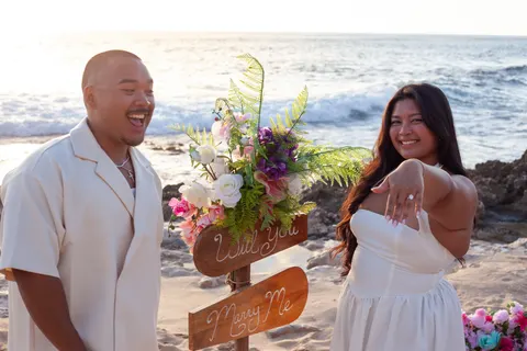 Showing off the ring by the welcome sign, at a horseback proposal on Oahu