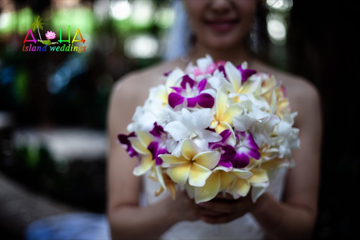 Yellow plumerias white and purple orchids make for a beautiful bouquet for this bride at the Hale koa hotel