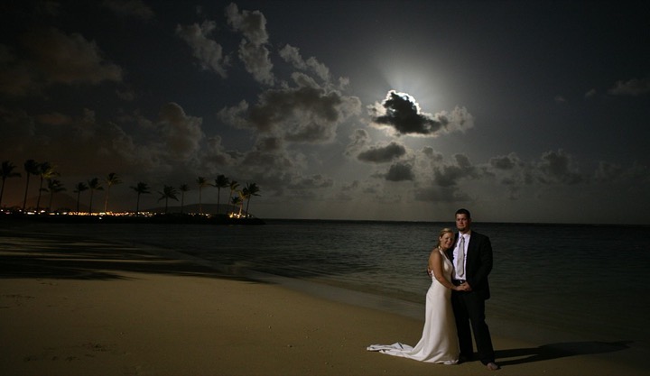 Couple on the beach under a full moon at the Kahala Resort