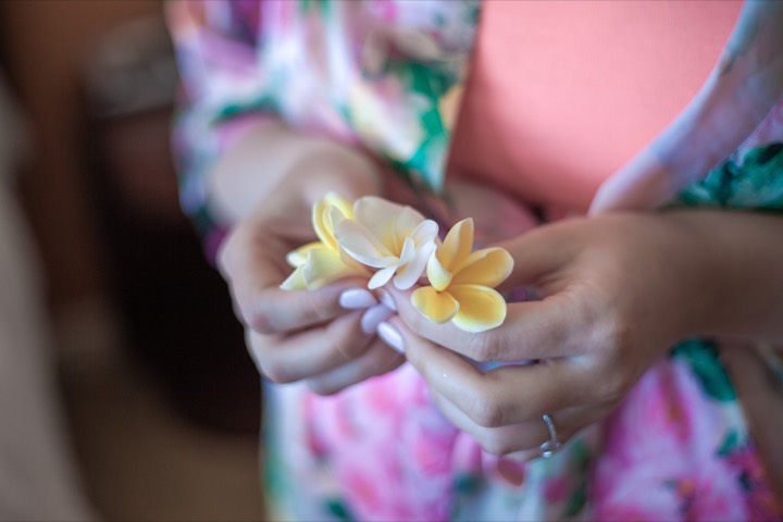 Lauren holding a plumeria flower for her hair while getting ready at the Hilton