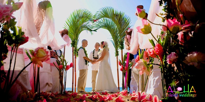 Palm arch with pink flowers at a Paradise Cove wedding