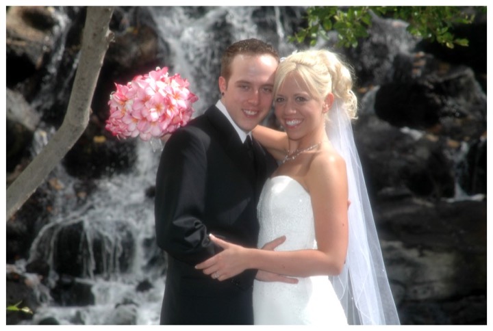Couple by the waterfall in the gardens of the Kahala Resort