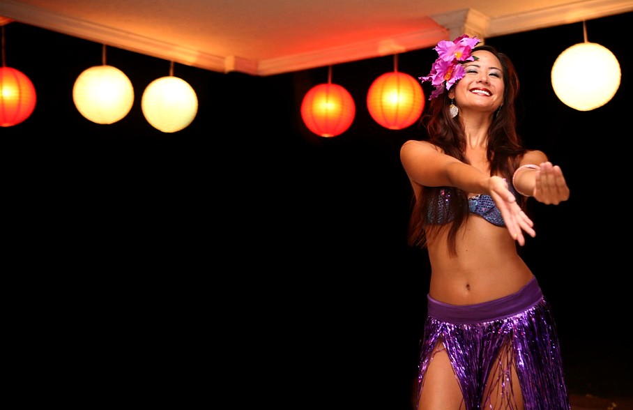 Hula dancer swaying her hips at the wedding reception pink estate house in Hawaii