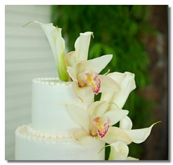 orchids and calla lillies ontop of the cake