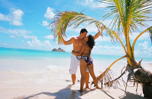 Jamillah and Brandon at Lanikai beach, under a blue sky