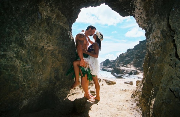 Jamillah and Brandon in a lava tube cave by the beach, looking at each other