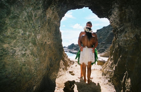 Jamillah and Brandon in a lava tube cave by the beach, laughing together