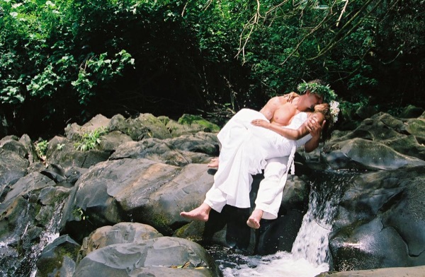 Jamillah and Brandon in the Nuuanu rainforest, under a blue sky
