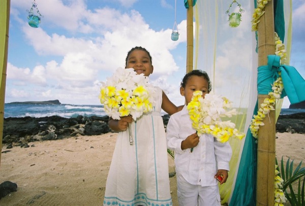 Kids playing with the yellow flower bouquets by the gazebo, in the sunshine