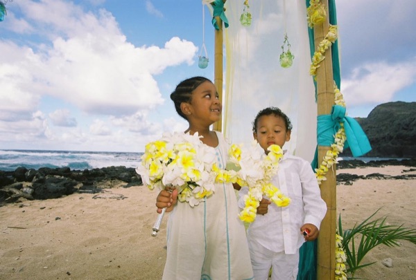 Kids playing with the yellow flower bouquets by the gazebo, laughing together