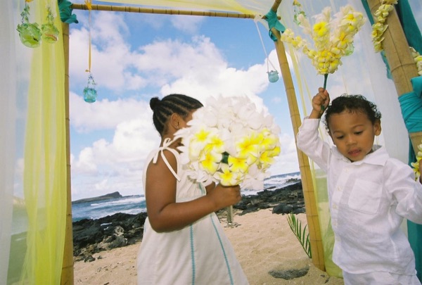 Kids playing with the yellow flower bouquets by the gazebo, side by side