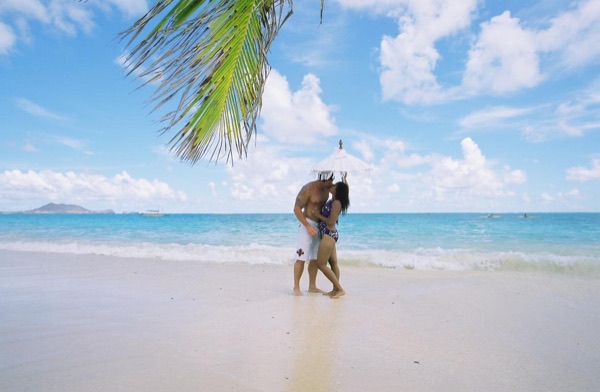 Jamillah and Brandon on the white sand at Lanikai, looking at each other