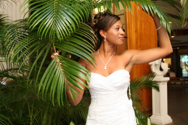 Jamillah by a palm in her wedding dress