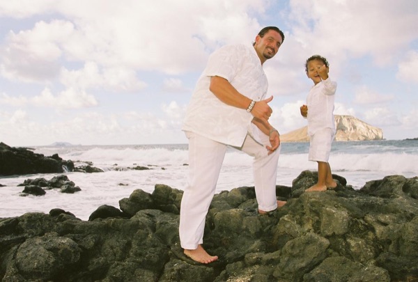 Brandon playing with his son Cameron on the beach, in the sunshine