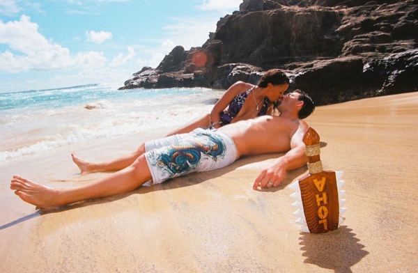 Brandon lying on the sand as the waves wash in at the cove, side by side