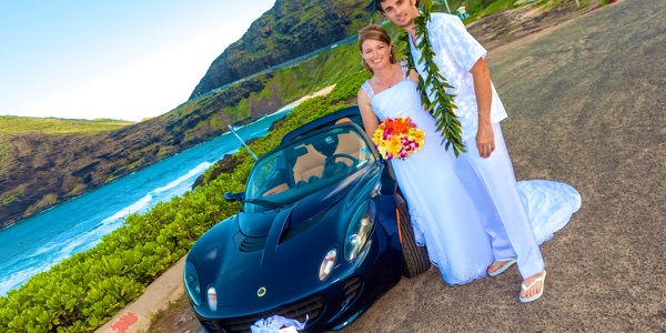 Jennifer and David with the blue Lotus sports car by the sea, a moment later