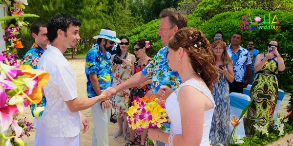Guests watching the ceremony by the turquoise water, a different view