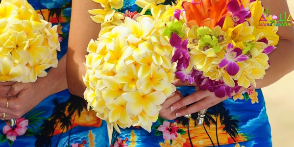 The groomsmen in bright aloha shirts on the beach