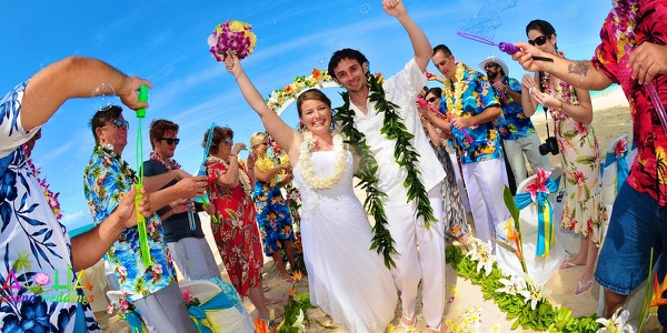The groomsmen in bright aloha shirts on the beach, another view