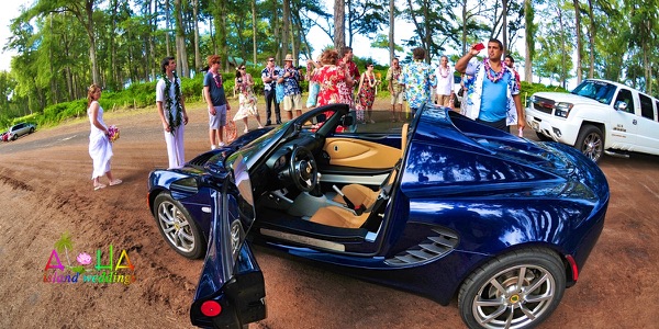 Jennifer and David with the blue Lotus sports car by the sea, a different view