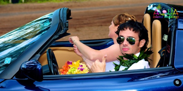 Jennifer and David with the blue Lotus sports car by the sea, another view