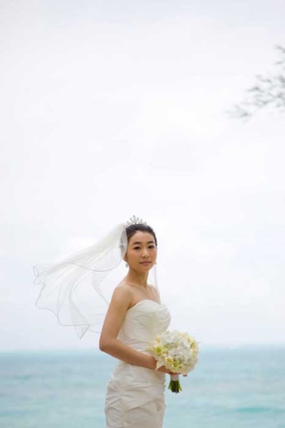 Sung holding her white Hawaiian bouquet on her wedding day