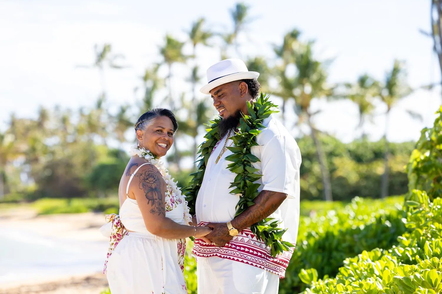 Jocelyn and Erick by the green bushes at the beach