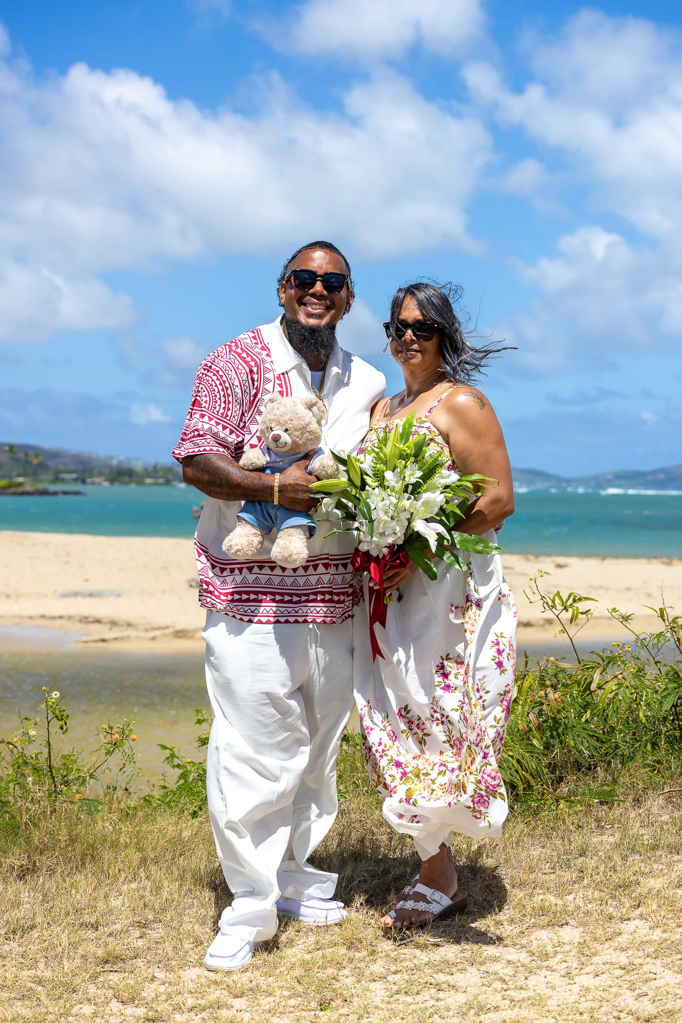 The couple on the sand with her bouquet