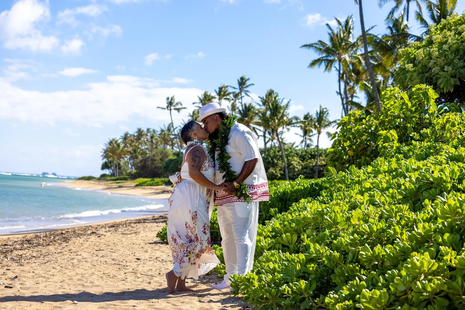 The couple on the shoreline with palm trees behind